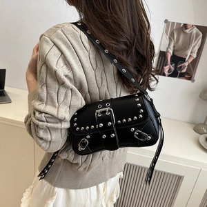Punk style black leather shoulder bag with silver studs and adjustable strap on a model