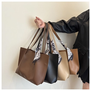 Close-up of four large faux leather tote bags in coffee, black, beige, and camel colors