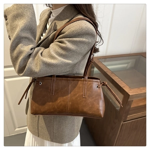 Detail einer braunen Vintage-Tasche mit Kordelzugknoten und gealterter Lederstruktur