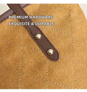 Détail d'un sac cabas en daim matelassé avec des rivets dorés et une bandoulière