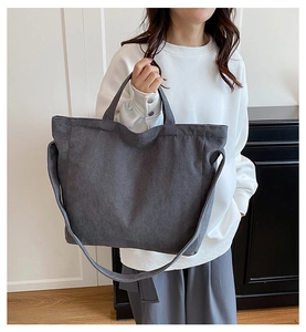 Texture dettagliata della borsa tote in velluto a coste grigio scuro con tracolla larga