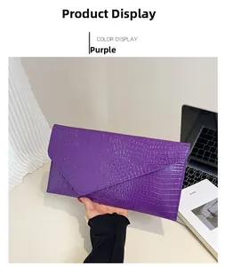 Detail der lila Briefumschlag-Clutch mit Krokodil-Prägung und glänzendem minimalistischem Design
