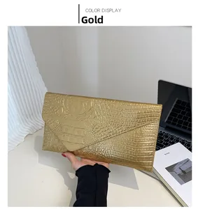 Detailaufnahme einer goldenen Clutch mit Krokoprägung in einer modernen Lifestyle-Umgebung