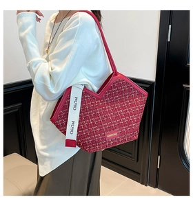 Close-up of red tweed tote bag featuring V-cut top edge and gold metal logo plaque