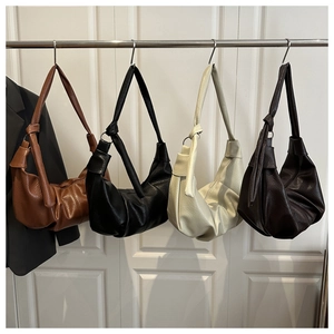 Detailed view of four minimalist soft leather crescent bags with knotted strap details