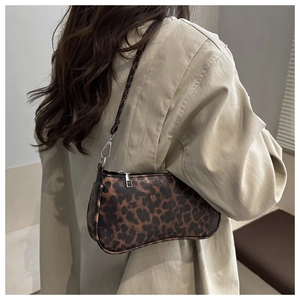 Detail of leopard print baguette bag featuring silver zipper and crescent moon shape