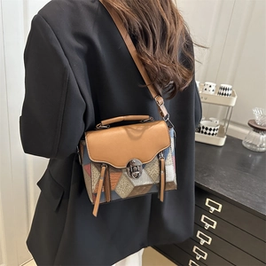 Chic geometric patchwork leather handbag with top handle and adjustable shoulder strap