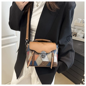 Close-up of a multi-color patchwork leather handbag with metal lock and textured panels