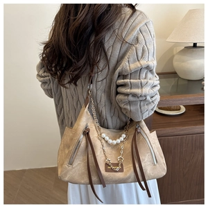 Détail du sac hobo en texture mate avec chaîne perlée et longues franges de côté