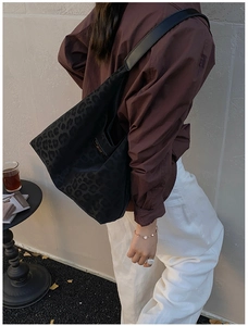 Close-up of black leopard print tote bag side view on model for daily commute style