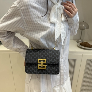 Sac à bandoulière noir monogramme avec chaîne dorée et fermoir métallique géométrique