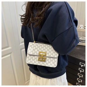 Détail du sac à bandoulière blanc avec chaîne dorée et boucle décorative en H