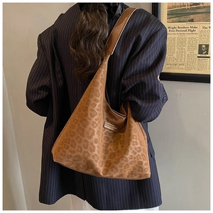 Detail view of large leopard print faux suede tote bag with wide shoulder strap