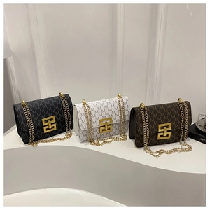 Close-up of quilted chain bags in black, white, and brown with gold geometric buckles