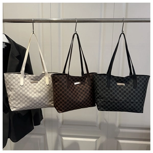 Close-up of three vintage tote bags with M-pattern print in white, tan, and black
