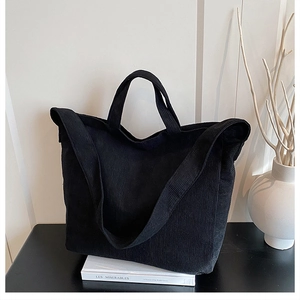 Dettaglio della borsa tote in velluto a coste nero con texture e tracolle rinforzate