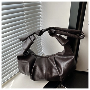 Detail of dark brown lychee leather hobo bag with pleated texture and knotted strap design