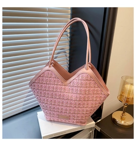 Detail of pink tweed tote bag showing woven texture, V-shaped leather trim and sleek strap