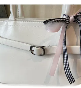 Détail du sac cabas blanc avec boucle en métal argenté et écharpe en soie à damier noir