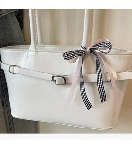 Détail du cabas en cuir PU blanc avec texture souple et décoration de ruban chic