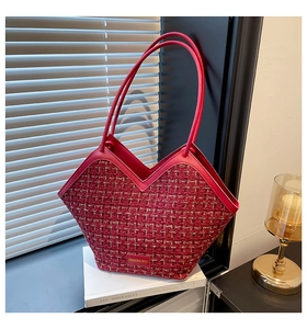 Detail of red tweed tote bag featuring V-shaped opening and gold brand metal plate