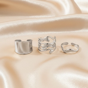 Three-piece stainless steel ring set with wide band and liquid metal designs on silk