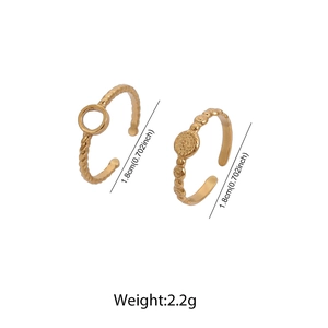 Close-up of gold stainless steel ring set with twisted texture and hollow circle detail