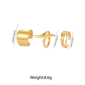 Detailed view of three gold wide-band chunky rings with matte and interlaced textures