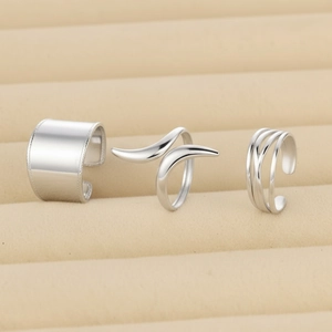 Three-piece silver stainless steel minimalist wide band and wrap ring set on jewelry box