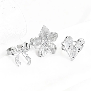 Set of silver stainless steel rings featuring butterfly, flower, and heart designs