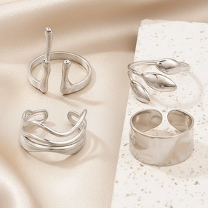 Set of four irregular stainless steel open rings with lava and leaf textured designs