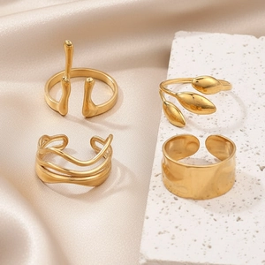 Set of four gold stainless steel rings with irregular textures and adjustable open bands