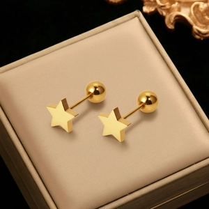 Golden geometric star stud earrings with ball screw back on a velvet jewelry box