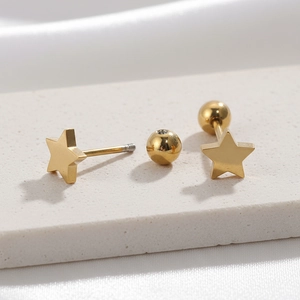 Golden geometric star stud earrings with secure screw ball back closure on white fabric