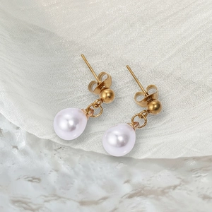 Vue détaillée de perles en forme de goutte sur des boucles d'oreilles en acier doré