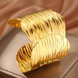 Polished 18k gold wave textured wide cuff bracelet made of stainless steel for women