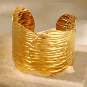 Detail of wide 18k gold plated stainless steel cuff with hammered water ripple texture