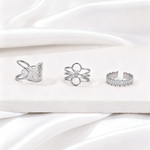 Three-piece silver stainless steel rings set featuring geometric textures on white silk