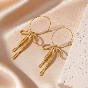 Boucles d'oreilles créoles en acier doré avec pendentifs nœuds élégants et fluides