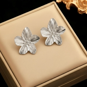 Elegant floral stud earrings in brushed silver finish displayed on a premium jewelry box pad