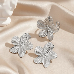 Elegant silver flower jewelry set with ring and earrings on premium champagne silk