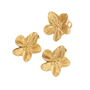 Minimalist gold flower jewelry set with open ring and stud earrings on white background
