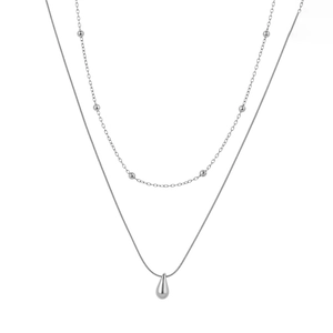 Double-layered stainless steel necklace featuring bead chain and teardrop pendant on white