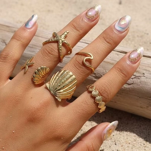 Detailed view of a 6-piece gold ocean themed ring set with starfish and shell designs