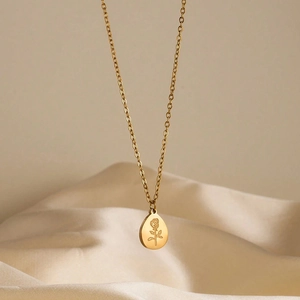 Detailed view of the 18K gold-plated oval rose pendant on a stainless steel chain