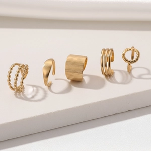 Detailed view of 5-piece 18K gold plated chunky ring set on white stone pedestals