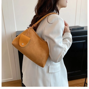 Détail du sac à bandoulière en daim fauve avec poche jaune et bandoulière froncée
