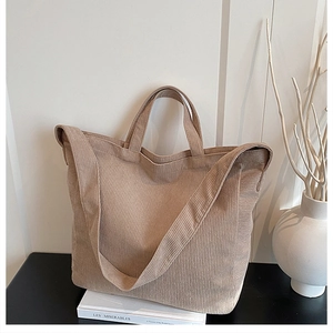 Dettaglio della borsa tote in velluto a coste beige con texture e doppi manici