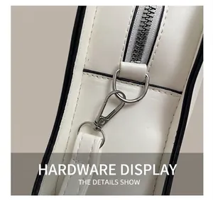 Detail of silver metal zipper and D-ring on white pebbled leather crossbody bag