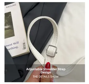 Close-up of the adjustable white leather shoulder strap with a silver metal buckle